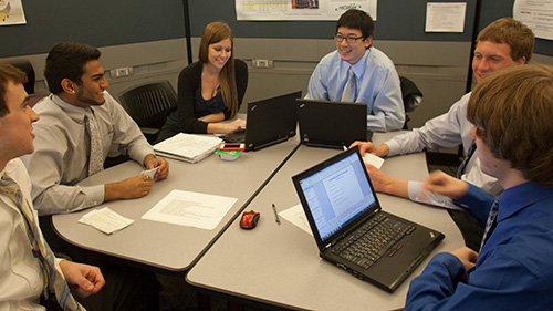 Group of students work on laptops for a group project for the Archer