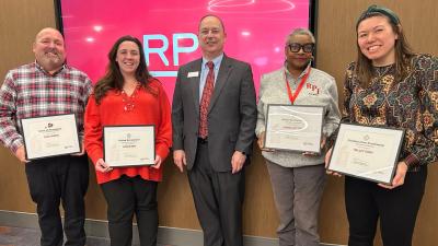 RPI staff members posing for a photo holding awards they received.