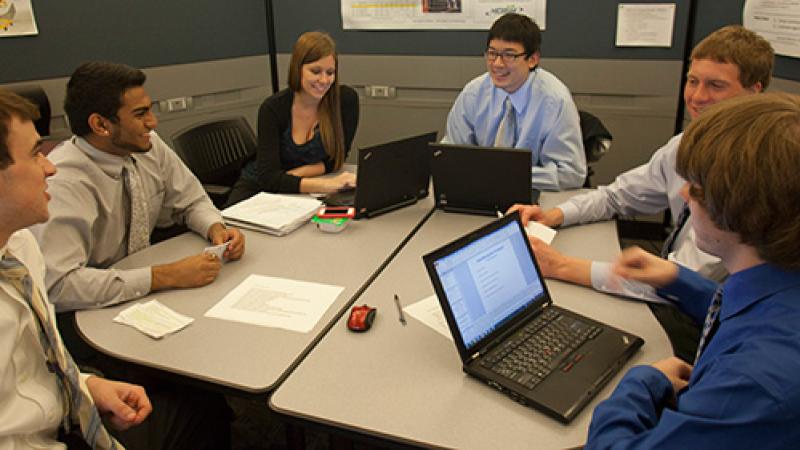 Group of students work on laptops for a group project for the Archer